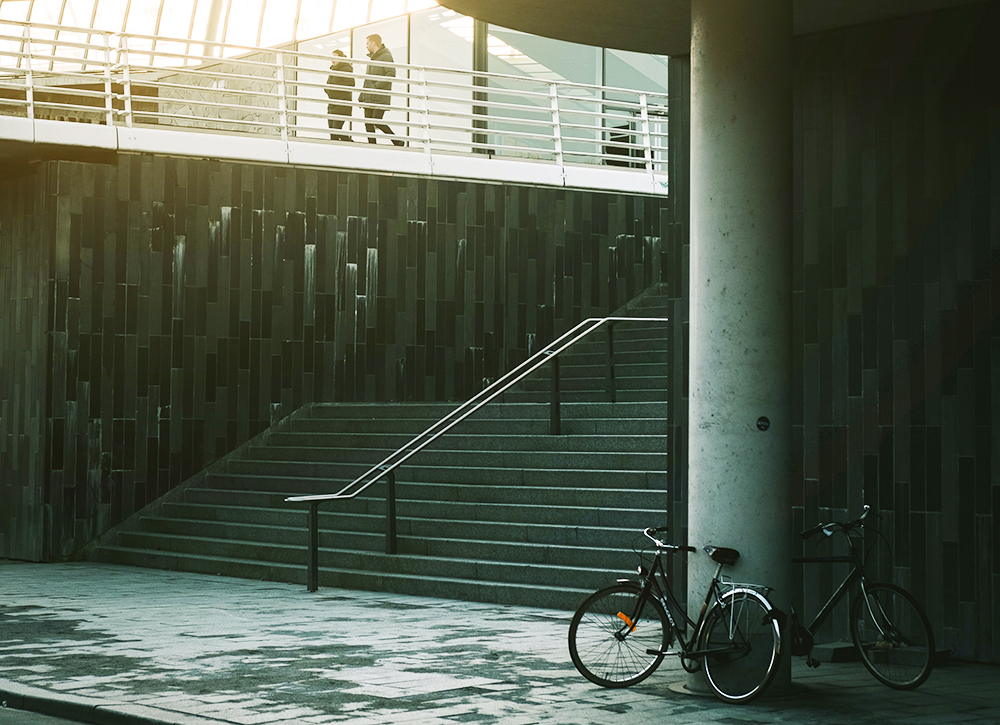 Bicycles and a large stairway in a city. Photo. 