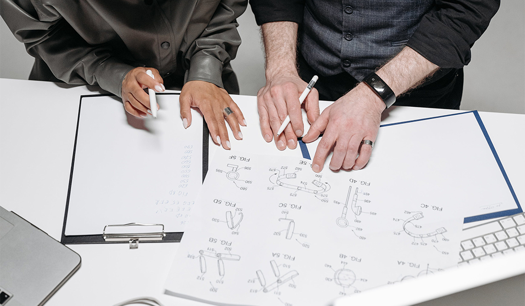 two people working on a design blueprint. Photo.