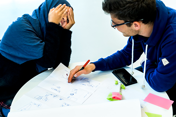 Two students working and laughing together. Photo.