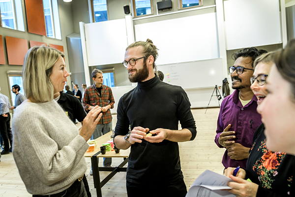 People in a big room talking together. Photo.